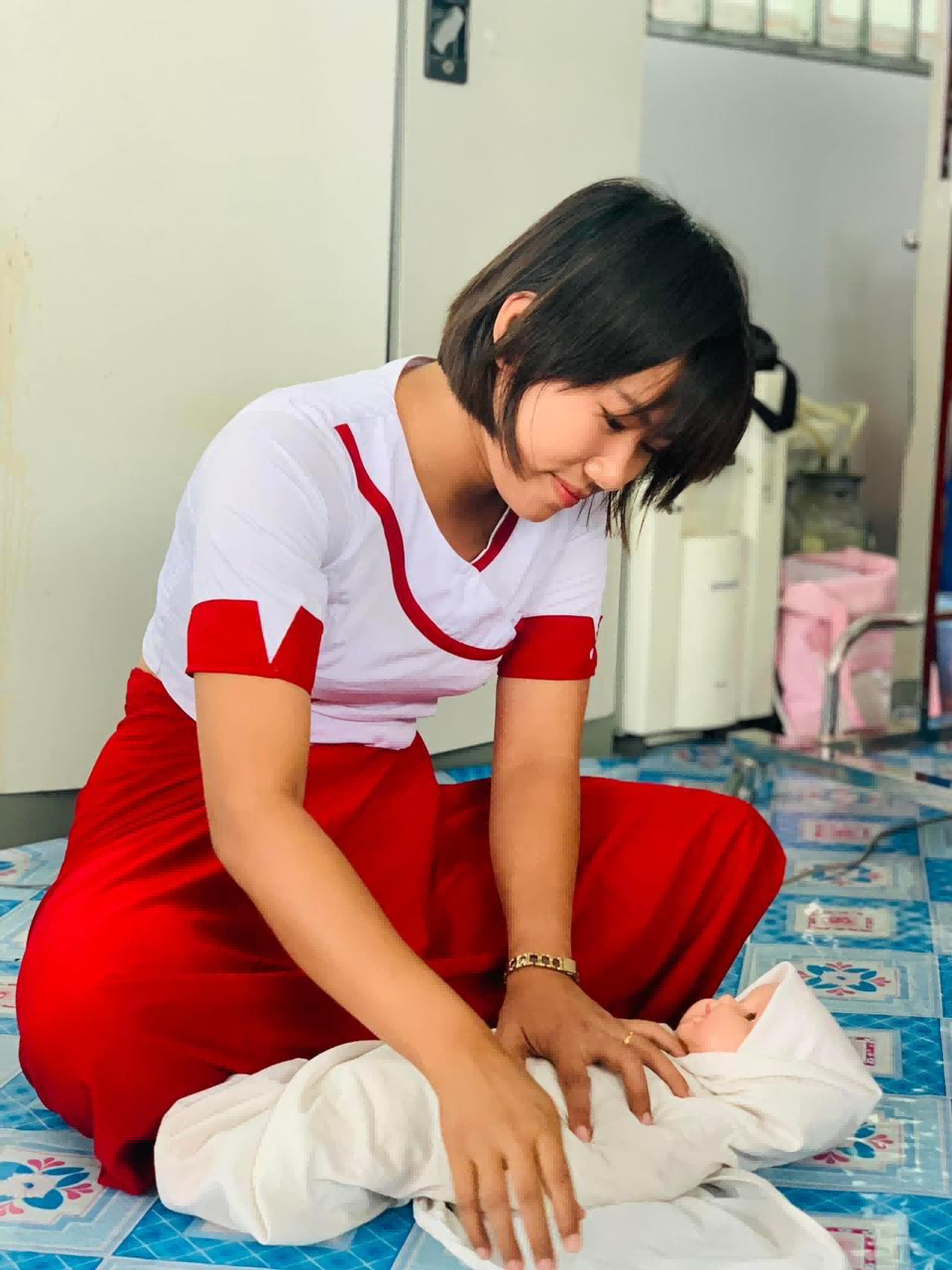 infant-baby-manikin-pediatric-training Healthcare trainee performs newborn care procedures on a durable infant manikin