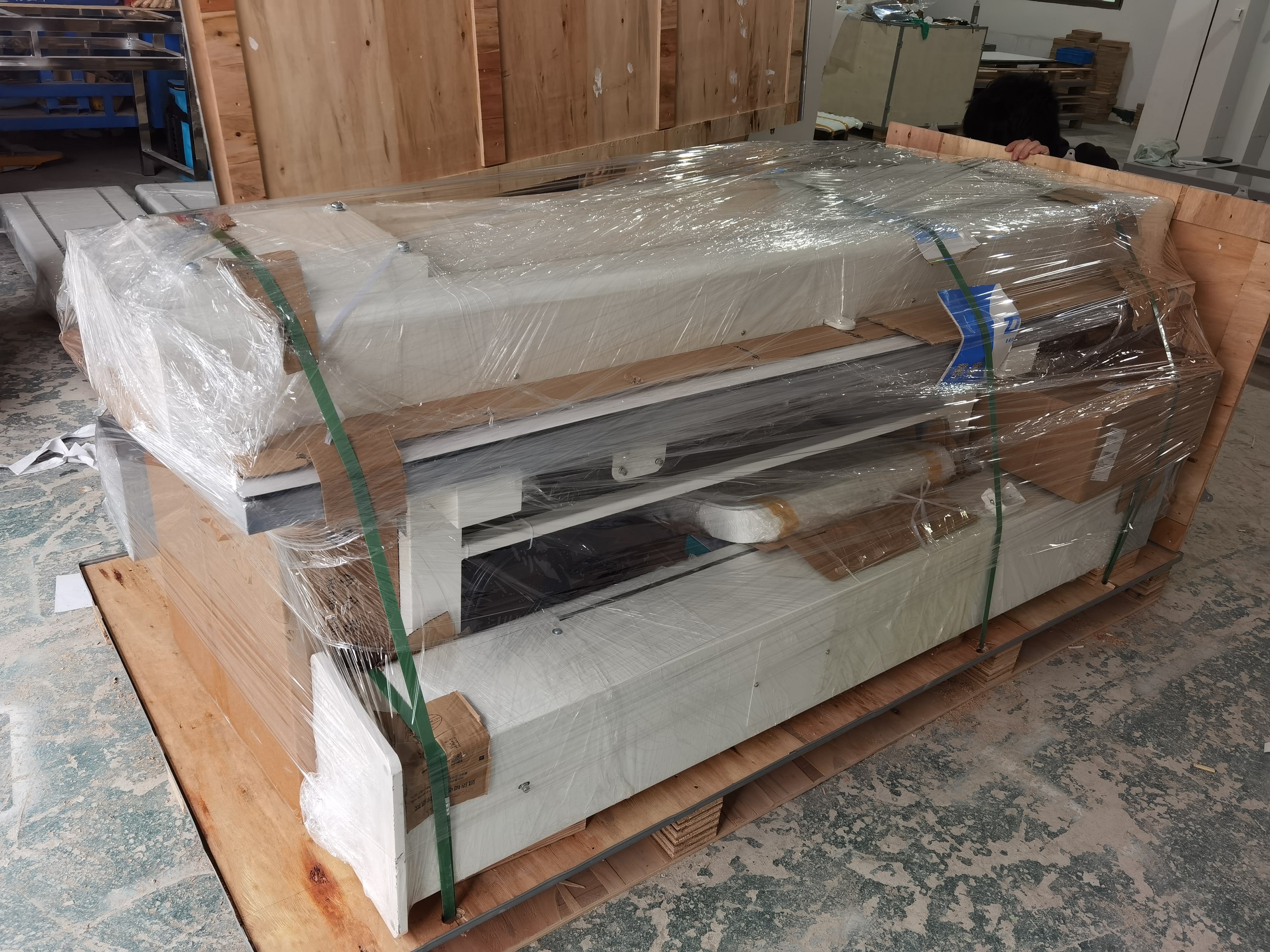 X-ray machine secured with reinforced plastic film and straps on shipping pallet for vibration-resistant transport