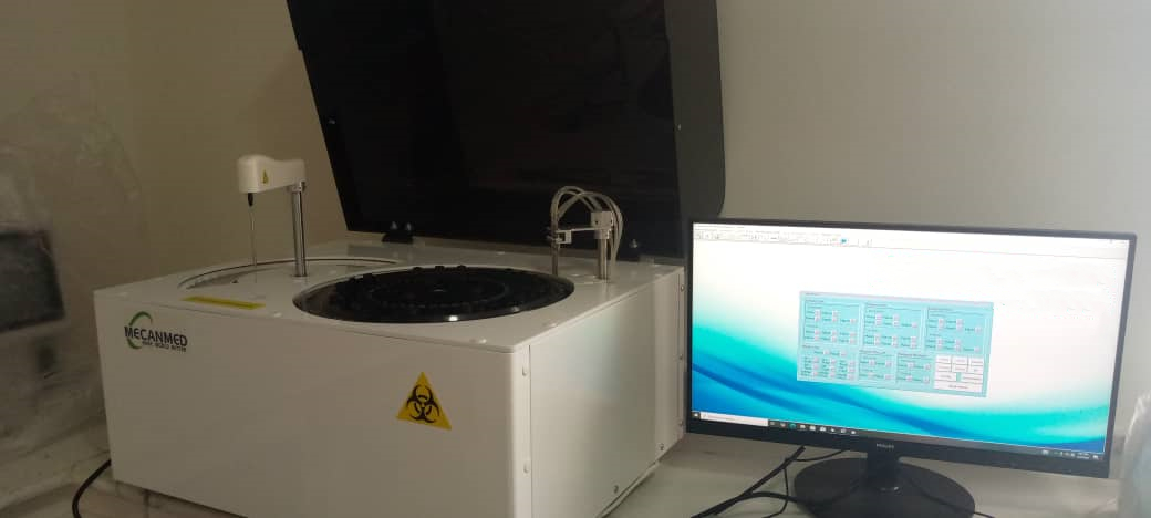 MeCanMed technician performing precise leveling of a Biochemistry Analyzer to ensure accurate reagent aspiration in a Cameroon hospital lab.