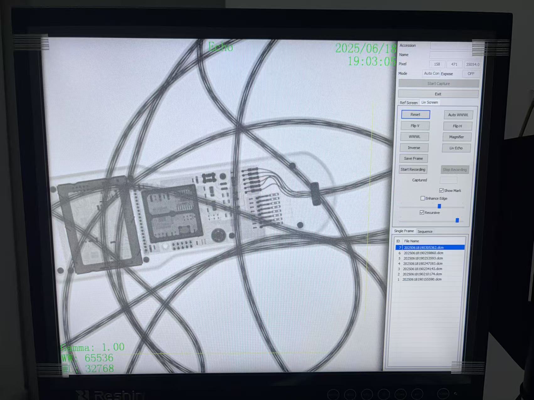 Monitor de bra&ccedil; en C que mostra una prova d'exposici&oacute; pr&egrave;via a l'entrega d'alt contrast mitjan&ccedil;ant una clau met&agrave;l&middot;lica per verificar la resoluci&oacute; de la imatge.