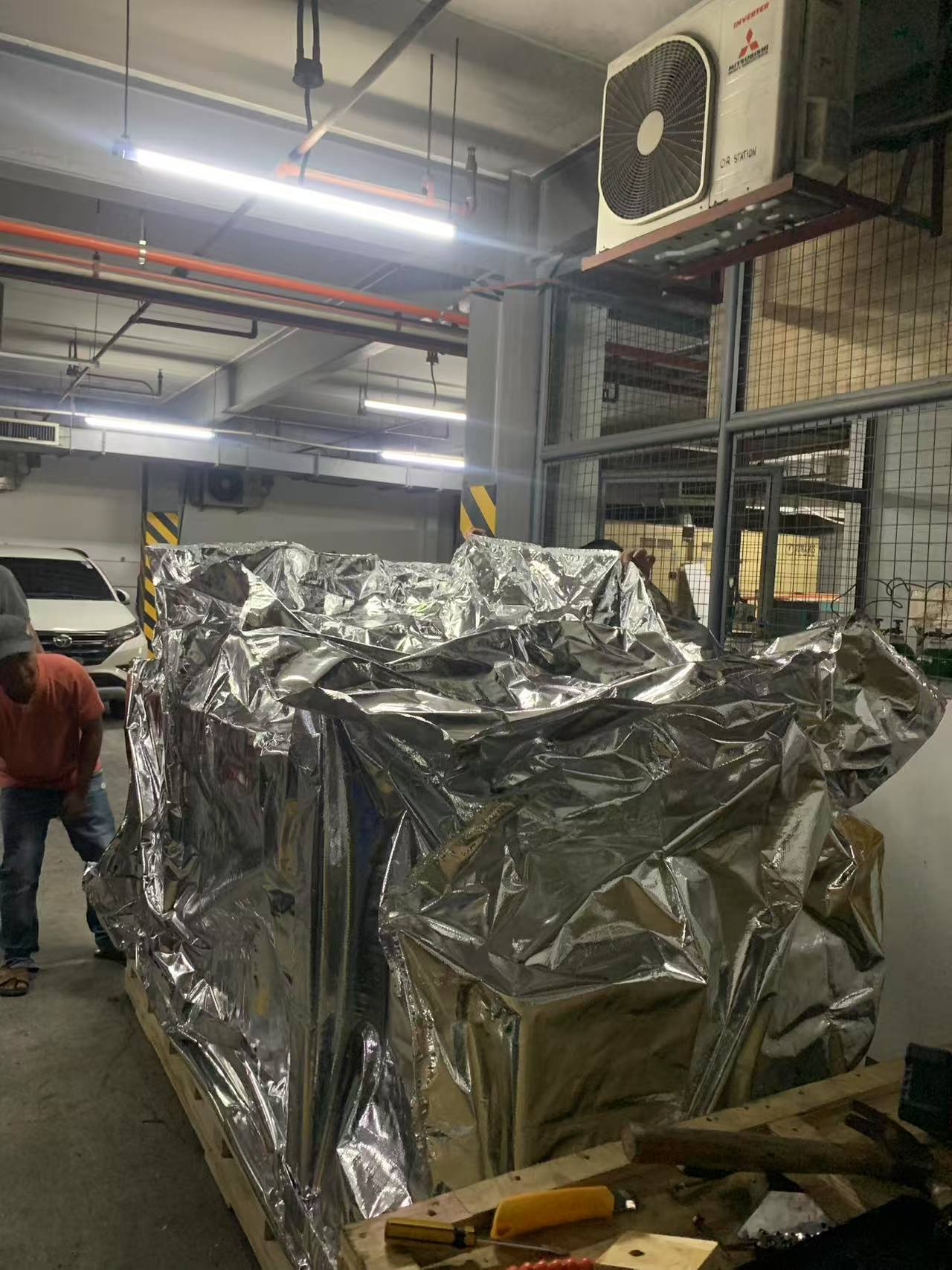 L'equip local va desembalar la pesada m&agrave;quina de bra&ccedil; en C de la seva barrera protectora contra la humitat en una instal&middot;laci&oacute; hospital&agrave;ria de les Filipines.