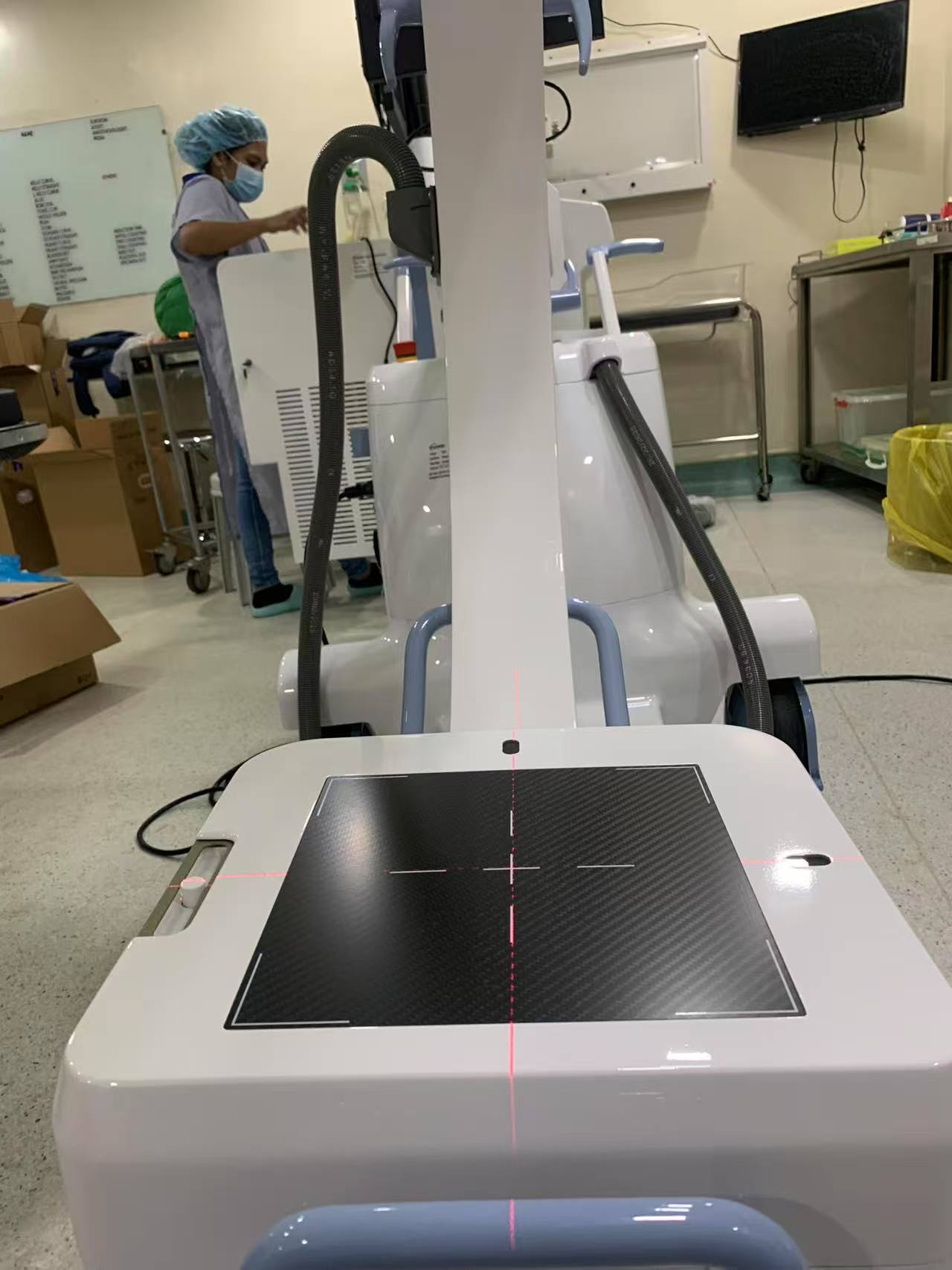 Un l&agrave;ser de creu vermella que alinea la l&iacute;nia central en un panell detector de bra&ccedil; en C dins d'un quir&ograve;fan d'un hospital filip&iacute;.